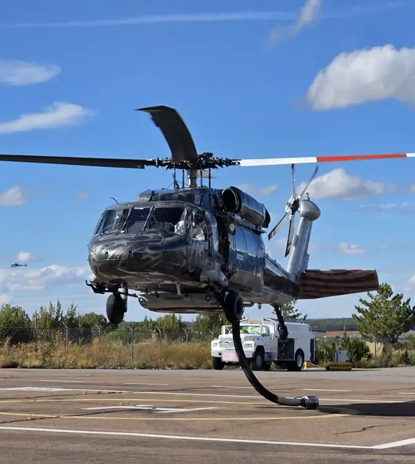 Castleberry UH-60 Black Hawk lifting off from a helipad, its red-and-white-tipped main rotor blades turning