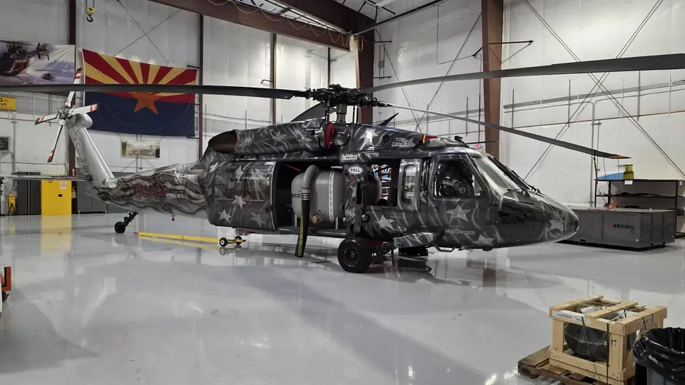UH-60 Black Hawk with a custom star livery in a hangar, an Arizona flag on the wall behind it